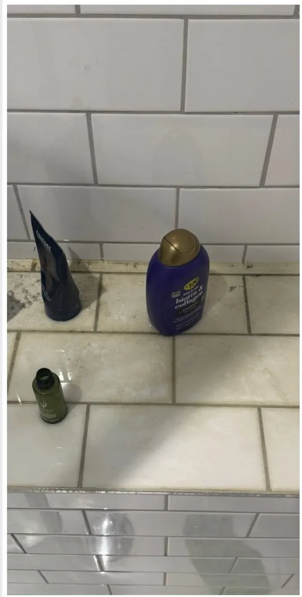 Dirty grey shower tile grout with soap scum before professional cleaning by True Grit Cleaning Co