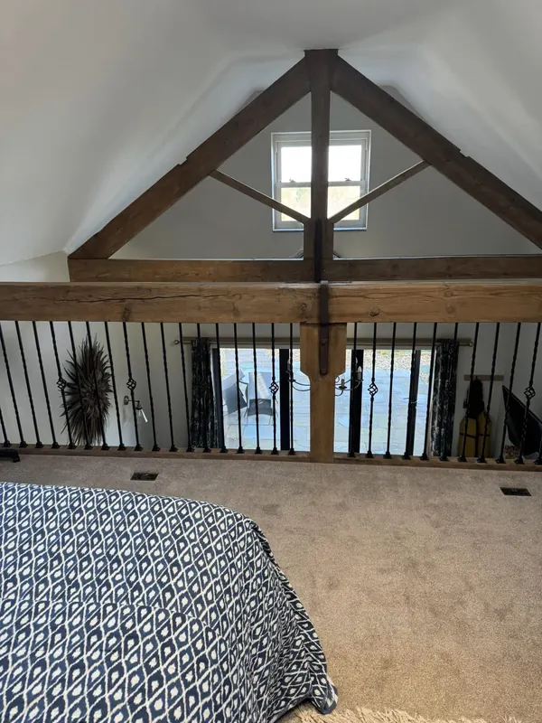 Vaulted-ceiling bedroom with exposed timber beams in a barn conversion holiday let cleaned by True Grit Cleaning Co